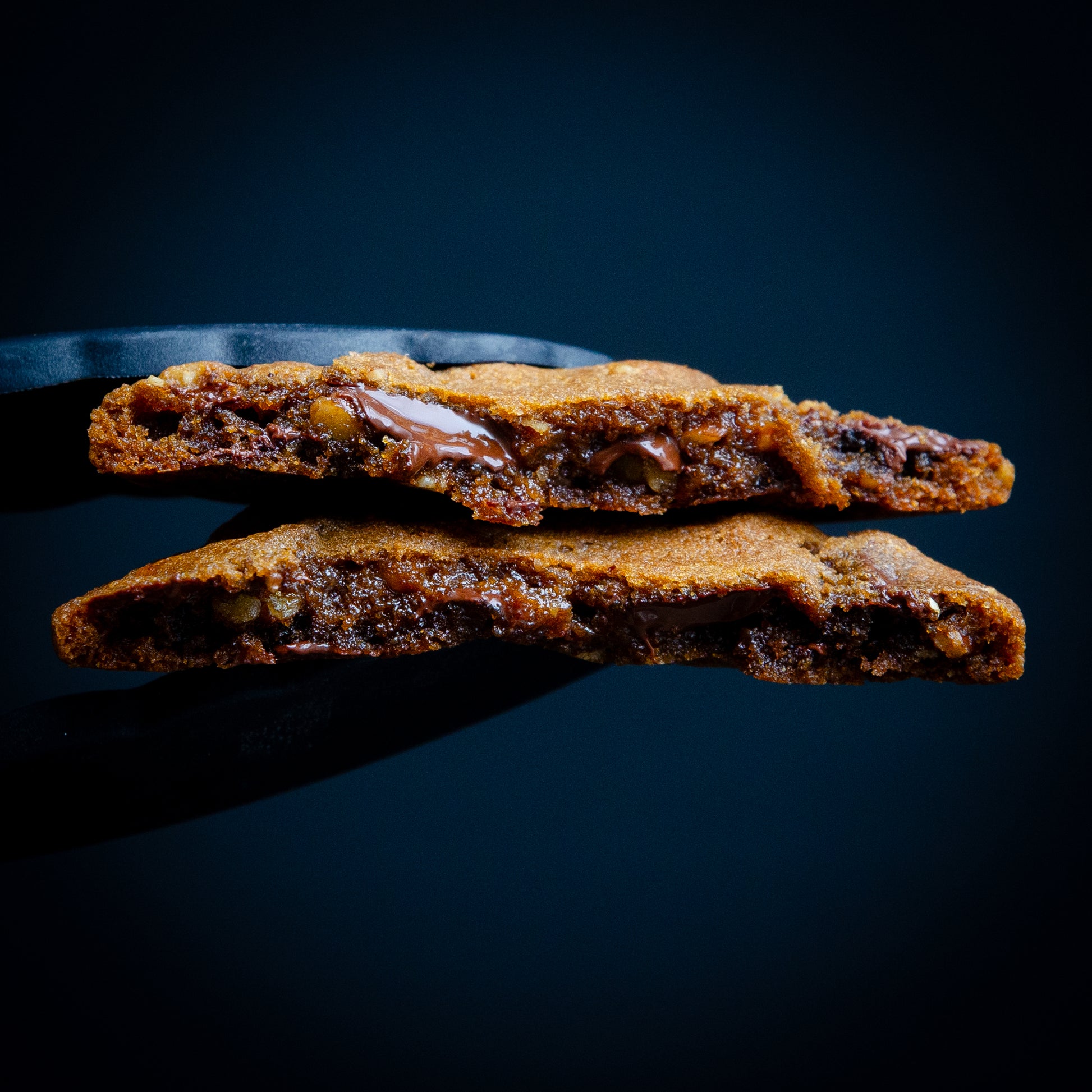 “Close-up of chewy chocolate chip cookie with Belgian chocolate chunks and toasted pecans.”